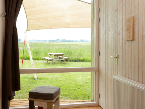 Vue depuis un hébergement glamping It Dreamlân Ecolodges Friesland sur une table de pique-nique et des prés.