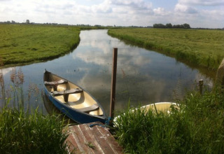 To både ligger ved en smal kanal omgivet af grønne marker hos It Dreamlân - Ecolodges Friesland.