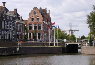 Vista de un canal y casas holandesas en Friesland, cerca del glamping It Dreamlân - Ecolodges.