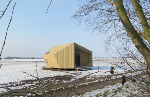 Modern glamping ecolodge at It Dreamlân, Friesland, set in a snowy landscape surrounded by open fields.
