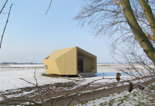 Moderna ecolodge de glamping en It Dreamlân, Friesland, en un paisaje nevado rodeado de campos abiertos.