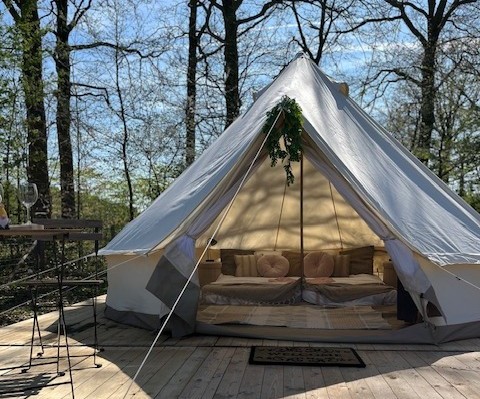 Luxuriöses Glamping-Zelt mit Betten und Kissen im Grünen bei Glamping Goed Van Den Bogaerde, Westflandern.