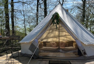 Luxuriöses Glamping-Zelt mit Betten und Kissen im Grünen bei Glamping Goed Van Den Bogaerde, Westflandern.