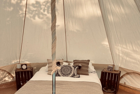 Interno di tenda glamping con letto accogliente da Glamping Goed Van Den Bogaerde nelle Fiandre Occidentali.