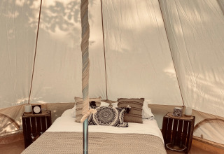 Intérieur de tente glamping douillet avec lit chez Glamping Goed Van Den Bogaerde en Flandre occidentale.