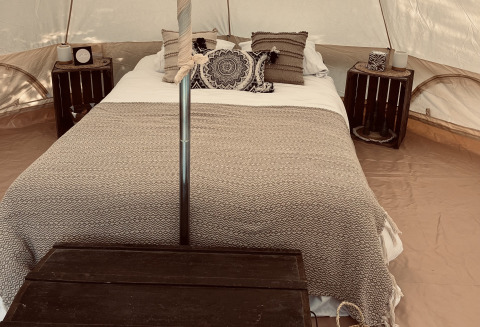 Hébergement glamping chez Glamping Goed Van Den Bogaerde à West-Vlaanderen, lit confortable sous tente décorative.