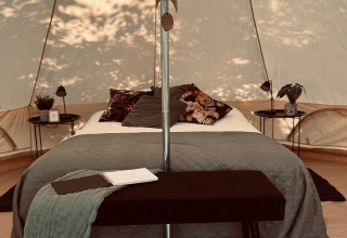 Luksuriøs glamping-indkvartering i telt med komfortabel seng og moderne indretning i Vestflandern.