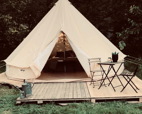 Glamping tent met houten terras en zitje bij Glamping Goed Van Den Bogaerde in West-Vlaanderen, België.