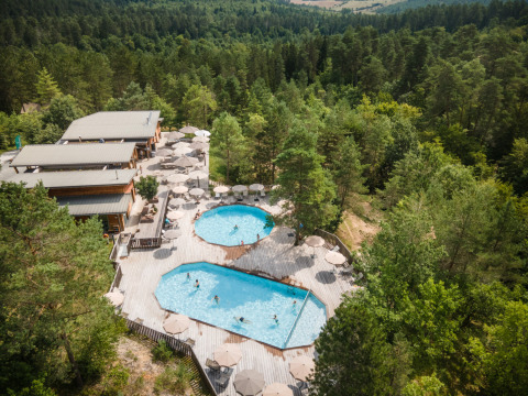 Vue aérienne des piscines et cabanes du Village Huttopia Lanmary-Périgord – Glamping Dordogne au cœur de la forêt.
