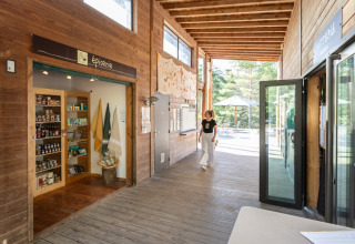 Indgang til butik og reception på Village Huttopia Lanmary-Périgord – Glamping Dordogne med træindretning.