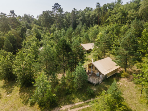 Glamping-indkvartering i Village Huttopia Lanmary-Périgord, omringet af Dordogne-skov, set fra oven.