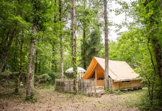 Hébergement glamping sous tente dans une forêt verdoyante au Village Huttopia Lanmary-Périgord en Dordogne.