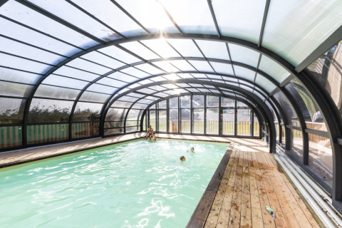 Piscina coperta con struttura in vetro e pavimento in legno presso Huttopia Vallée de la Semois, Ardenne, glamping.