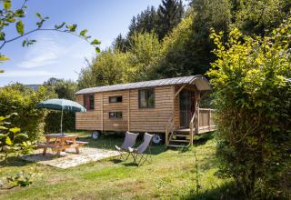 Alloggio glamping in legno presso Huttopia Vallée de la Semois, circondato da natura rigogliosa e tranquillità.