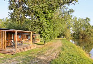 Alloggi glamping in legno sul lago presso Huttopia Baie du Mont Saint Michel, immersi nella natura.