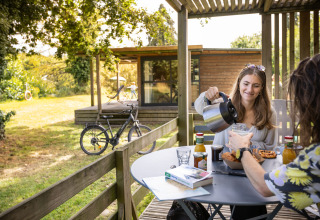 Zwei Personen frühstücken im Freien bei Huttopia Baie du Mont Saint Michel, Glamping Bretagne.