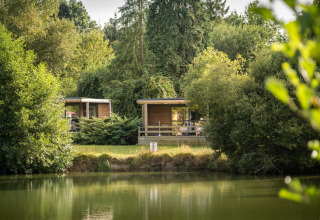 Cabine glamping sul lago circondate dal verde presso Huttopia Baie du Mont Saint Michel in Bretagna, Francia.