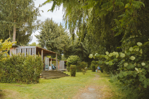 Glampingaccommodatie bij Huttopia Baie du Mont Saint Michel in Bretagne met houten huisjes en veel groen.