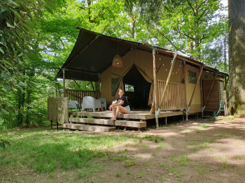 Alojamiento glamping Vieflow Lodge Dordogne, tienda moderna rodeada de bosque verde y ambiente natural.