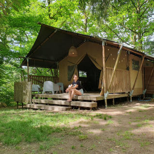 Glamping-Unterkunft Vieflow Lodge Dordogne, modernes Zelt inmitten üppiger Bäume und entspannter Atmosphäre.