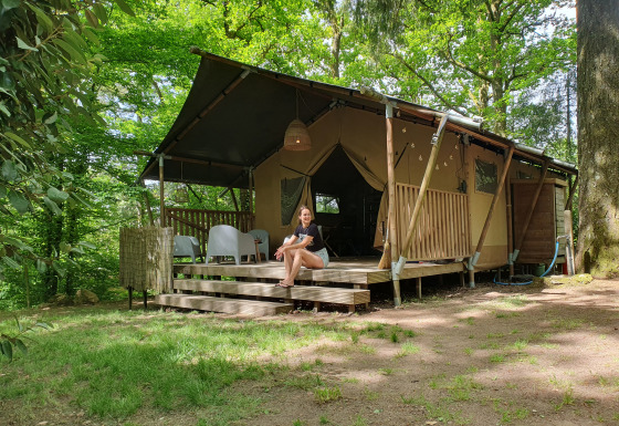 Glampingindkvartering Vieflow Lodge i Dordogne, moderne telt i natur omgivet af træer og grønne omgivelser.