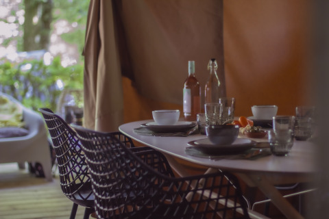 Buiten eettafel bij Vieflow Lodge - Lodgetenten Dordorgne met servies en uitzicht op natuur.