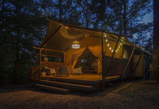 Tenda glamping illuminata presso Vieflow Lodge - Lodgetenten Dordogne nel bosco al crepuscolo.