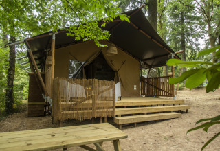 Glamping-accommodatie Vieflow Lodge in de Dordogne met lodgetenten en houten terras in het bos.