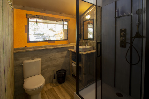 Badeværelse med bruser, toilet og håndvask i glampingindkvartering hos Vieflow Lodge - Lodgetenten Dordorgne.