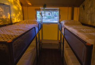 Interior of Vieflow Lodge - Lodgetenten Dordogne, showing bunk beds in a cozy glamping tent setting.