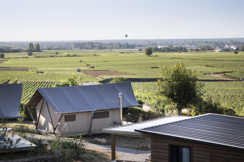 Glampingverblijf bij Huttopia Meursault met luxetenten en zicht op de zonnige wijngaarden van Bourgogne.