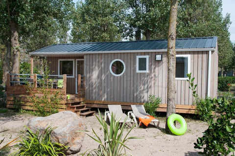 Alloggio glamping moderno al Camping Beach Garden con veranda, sdraio e alberi nel sud della Francia.