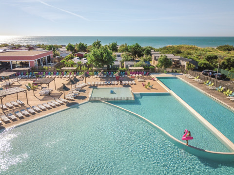Großer Poolbereich mit Liegestühlen im Camping Beach Garden - Glamping Zuid-Frankrijk am Meer.