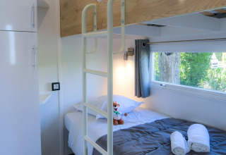 Innenraum eines Glamping-Mobilheims bei Camping Beach Garden mit Etagenbett, Fenster und modernem Design.