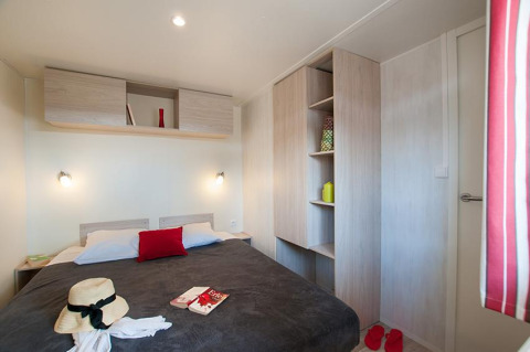 Modern glamping accommodation at Camping Beach Garden in South France with cozy bedroom and storage units.