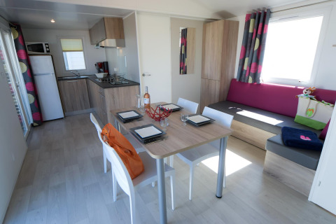 Moderne glampingindkvartering på Camping Beach Garden i Sydfrankrig med køkken og spiseområde.