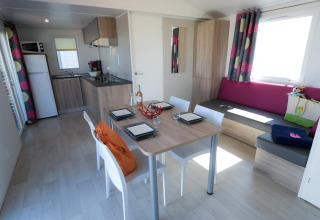 Moderne Glamping-Unterkunft im Camping Beach Garden Südfrankreich mit Küche, Esstisch und Sofa.