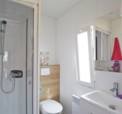 Modern glampingbadkamer met douche, toilet, wastafel en spiegel bij Camping Beach Garden in Zuid-Frankrijk.