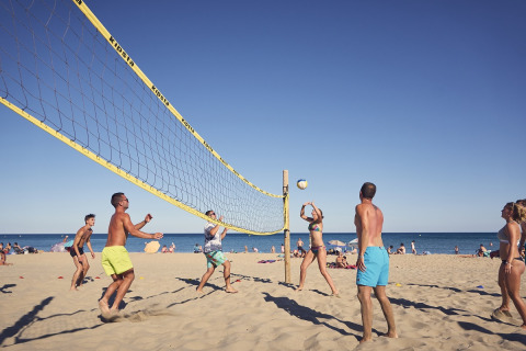 People enjoy a game of beach volleyball at Camping Beach Garden - Glamping Zuid-Frankrijk on a sunny day.