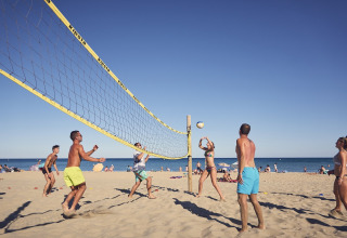 Mensen spelen beachvolleybal op het zand bij Camping Beach Garden - Glamping Zuid-Frankrijk onder de zon.
