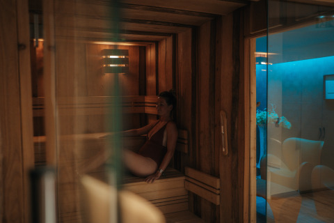 Woman relaxing in sauna at Camping Beach Garden - Glamping Zuid-Frankrijk, cozy luxury glamping facility.