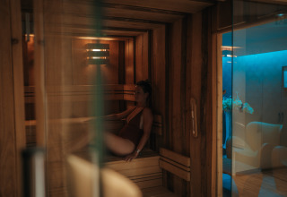 Vrouw geniet van een sauna in Camping Beach Garden - Glamping Zuid-Frankrijk, gezellig wellnessgedeelte.