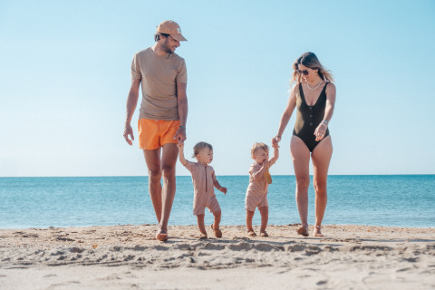 Famiglia con due bambini piccoli passeggia sulla spiaggia al Camping Beach Garden - Glamping Zuid-Frankrijk al sole.