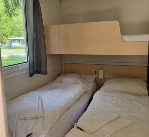 Vista interior de alojamiento glamping en Glamping Bad Gastein - Kurcamping Erlengrund con literas.