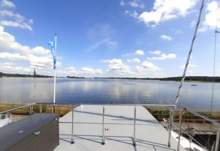 Udsigt fra Wind & Wellen - Woontboot Sleeswijk-Holstein med rolige vande, blå himmel og skyer.