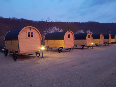 Caravanas de glamping en Camping Gülser Moselbogen - Herderwagens, iluminadas por la noche en Renania-Palatinado.