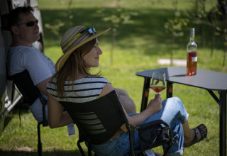 Zwei Personen entspannen mit einem Glas Wein beim Glamping auf dem Camping Gülser Moselbogen - Herderwagens Rheinl.-Pfalz.