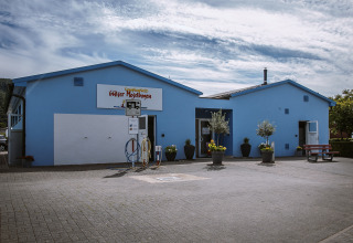 Blauw gebouw bij Camping Gülser Moselbogen met faciliteiten en planten, Rijnland-Palts