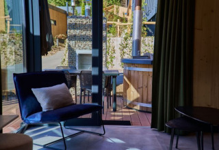 Innenraum von Glamping in UplandParcs Sauerland Wellness Cottage mit Blick auf Terrasse und Badezuber.