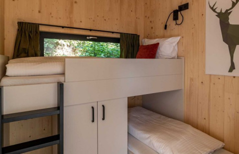 Acogedora zona de literas con paredes de madera en UplandParcs Sauerland Wellness Cottage, Renania del Norte.